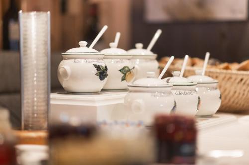 a group of four white tea pots on a table at Samnaunerhof Vital-Hotel in Samnaun
