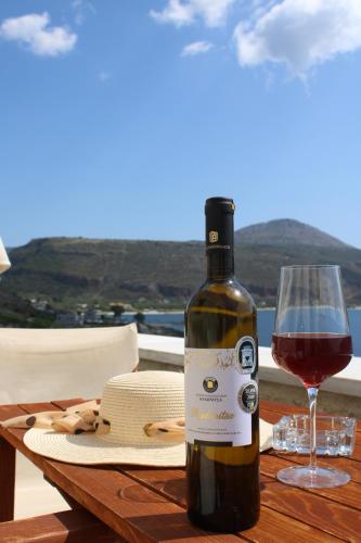 uma garrafa de vinho e um copo sobre uma mesa em Εn Plo Luxury Suites em Karavostasion