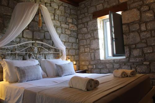 a bedroom with a bed with two towels on it at Εn Plo Luxury Suites in Karavostasi