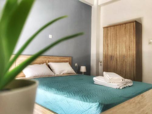 ein Schlafzimmer mit einem Bett mit Topfpflanze in der Unterkunft Midway Point Apts in Iraklio