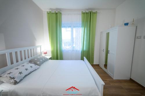 una camera da letto con un letto bianco con tende verdi di Casa stellata Napoli home in the center a Napoli