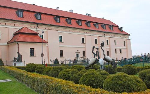 a building with a statue of birds in front of it at Pokoje Gościnne z łazienkami in Niepołomice