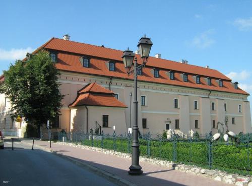 a large white building with a red roof at Pokoje Gościnne z łazienkami in Niepołomice