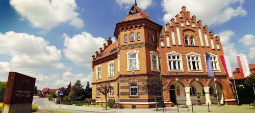 a large brick building with a tower on top at Pokoje Gościnne z łazienkami in Niepołomice