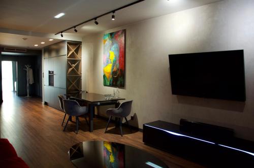 - un salon avec une table et une télévision murale dans l'établissement Aparts Hotel Radom, à Radom