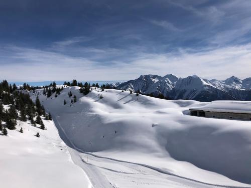 a snow covered mountain with mountains in the background at Hamilton Lodge & Spa in Belalp
