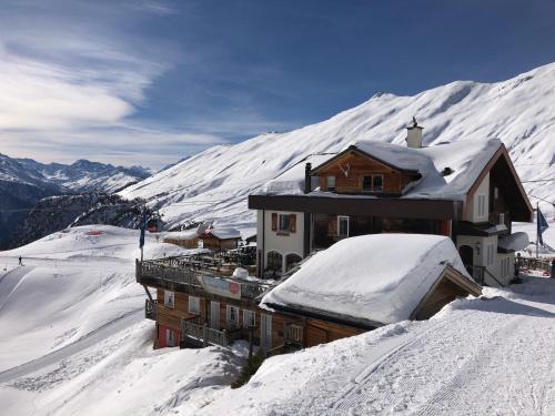 a house on a snowy mountain with snow covered roofs at Hamilton Lodge & Spa in Belalp