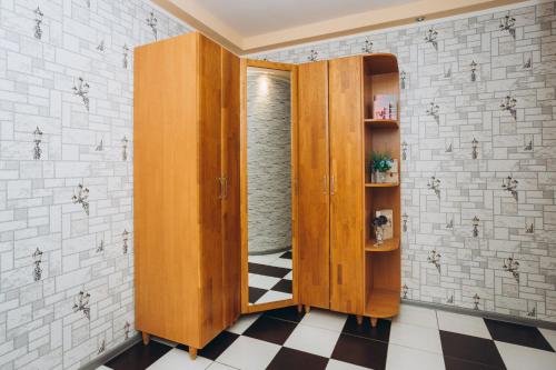 een kamer met houten kasten en een geruite vloer bij Apartment on Kharkovskaya 2 floor in Sumy
