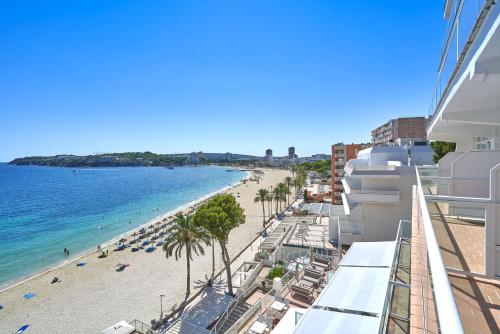 a view of a beach with palm trees and the ocean at Flamboyan Caribe Hotel & Spa in Magaluf
