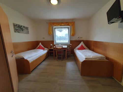 Zimmer mit 2 Betten und einem Tisch in der Unterkunft Gästehaus Ermen in Kamp-Lintfort