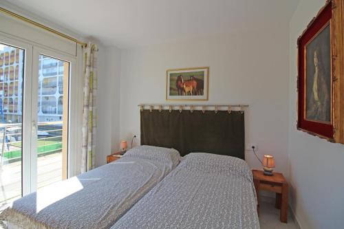 Ce lit se trouve dans une chambre dotée d'une grande fenêtre. dans l'établissement Apart-rent Apartment Port Salins 0163, à Empuriabrava