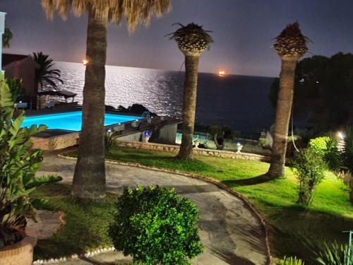 a resort with palm trees and the ocean at night at Estrena loft en el mejor sitio de Tarragona in Tarragona