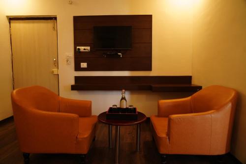 two orange chairs and a table in a room at Suraksha Stay ITPL Hotel Banglore in Bengaluru