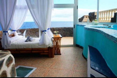 a room with a bed and a view of the ocean at Romantic Tenerife in Güimar