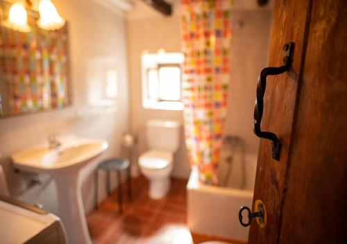 uma casa de banho com um lavatório e um WC em Cal Conxé em El Vilosell
