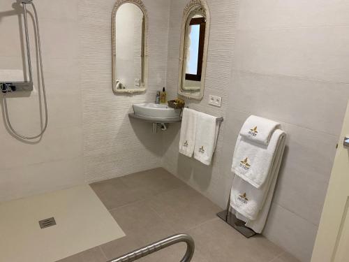 a white bathroom with a sink and a mirror at Hotel boutique Palacio de la Veracruz in Alcalá la Real