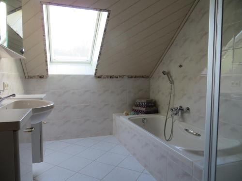 a bathroom with a shower and a tub and a sink at Ferienwohnungen Breternitz in Steinach
