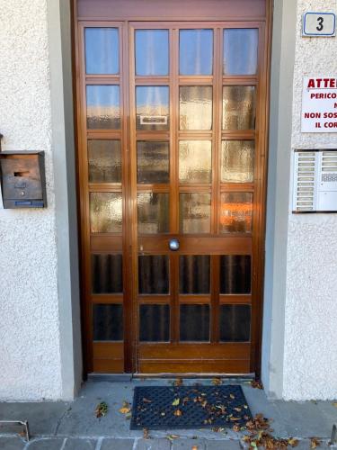 une porte en bois avec des panneaux de verre sur un bâtiment dans l'établissement Monolocale Cerreto Laghi, à Cerreto Laghi