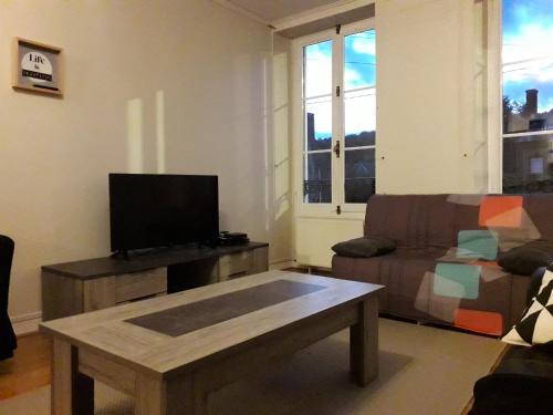 ein Wohnzimmer mit einem Sofa und einem Couchtisch in der Unterkunft Appartement 80m2 dans belle demeure in Vrigne-aux-Bois