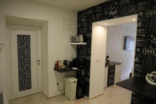 una cucina con una parete nera e una scrittura di Love Nest apartment a Lubiana