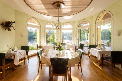 溫迪西里茲的住宿－Fischhaus Am Kleinen Glubigsee，一间设有白色桌椅和窗户的用餐室