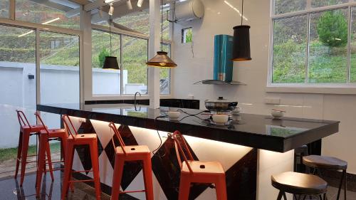 Una cocina con un mostrador con sillas alrededor. en Rose Hill Gardens, en Brinchang