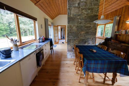 uma cozinha e sala de jantar com mesa e cadeiras em Kerrow House em Cannich