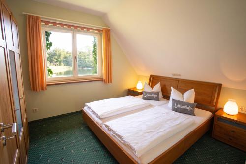 a bedroom with a bed with two lamps and a window at Fischhaus Wendisch Rietz in Wendisch Rietz
