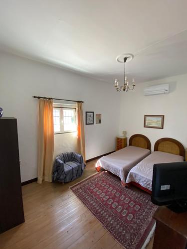 a bedroom with two beds and a television in it at Casa do Morgado do Casco in Estremoz