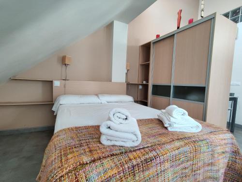 マラガにあるLa Buhardilla de Hinestrosaのベッドルーム1室(ベッド2台、ベッド上にタオル付)