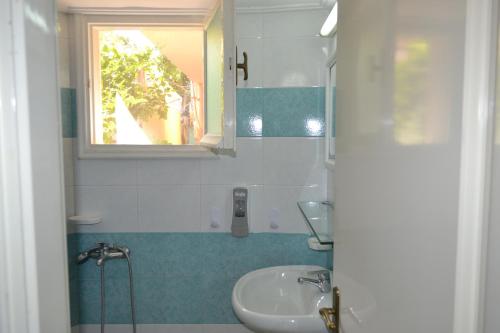 a small bathroom with a sink and a mirror at Tilegrafos Studios in Lefkada