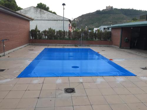 una gran piscina azul en un patio en TU CASA EN MEQUINENZA CON WIFI, en Mequinenza