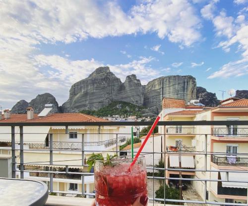 a drink sitting on a table with a view of mountains at Meteora 360 Apartment by Meteora Residencies in Kalabaka