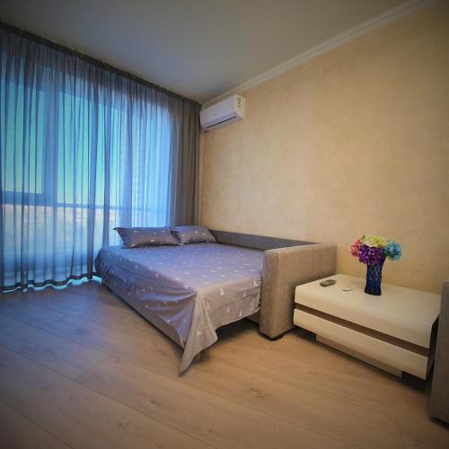 a bedroom with a bed and a large window at Rent VIP apartment in Kyiv in Kyiv