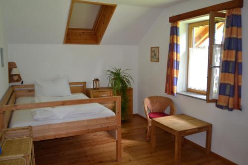 um quarto com uma cama, uma cadeira e uma janela em Ferienwohnung Zauner em Hallstatt
