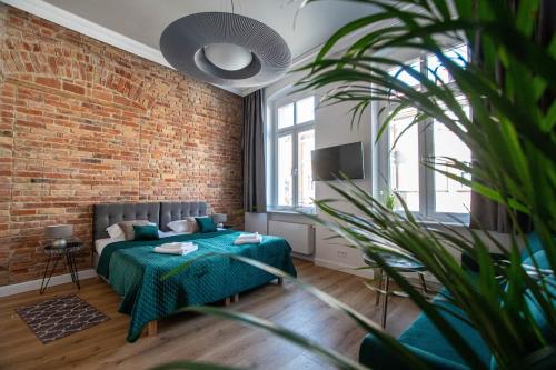 a bedroom with a bed and a brick wall at Kamienica1899 in Szczecin