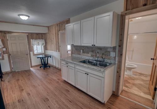a kitchen with white cabinets and a sink at Outer Banks Motel - Village Accommodations in Buxton