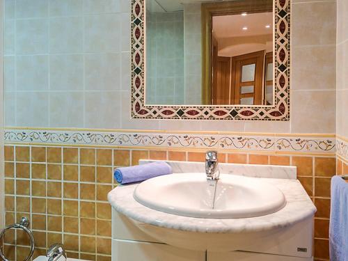 Apartamentos Torreon Del Mar في بينالمادينا: حمام مع حوض ومرآة