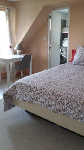 1 dormitorio con cama, mesa y escritorio en Chambres d'hôtes Olry, en Nancy