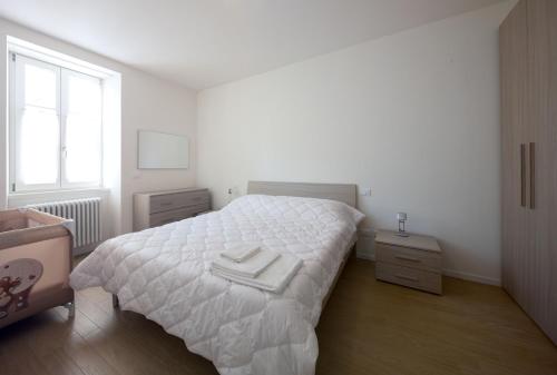 una camera bianca con un letto bianco e una finestra di I Dodici mesi - appartamento Primavera a Trento