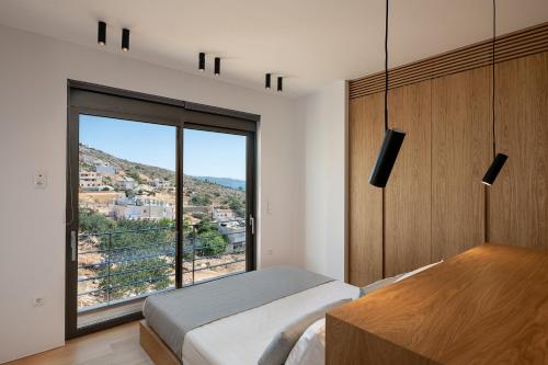 a bedroom with a bed and a large window at Seametry Luxury Living Penthouse in Souda