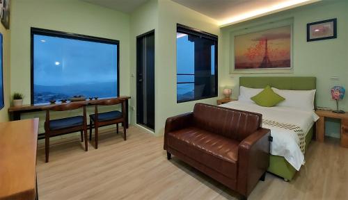 a bedroom with a bed and a chair and a table at Dosun B&B in Jiufen
