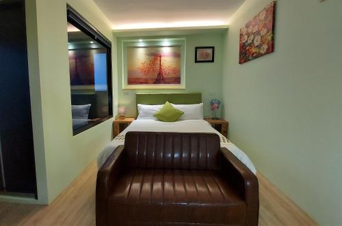 a bedroom with a bed and a leather couch at Dosun B&B in Jiufen