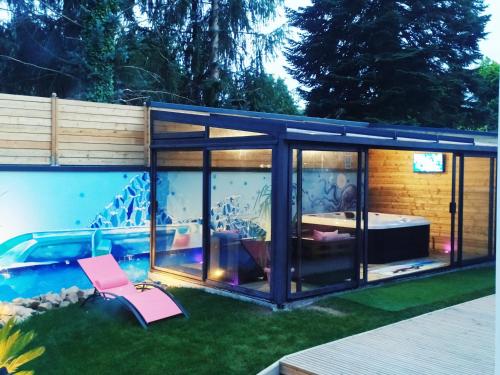 une maison en verre avec une piscine dans la cour dans l'établissement LOGEMENT ATYPIQUE BIEN ETRE AU CŒUR DE LA NATURE, à Quimper