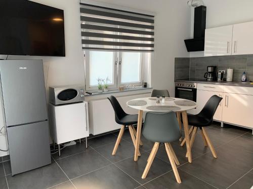 eine Küche mit einem Tisch und Stühlen in einer Küche in der Unterkunft H&E Apartments Barntrup in Barntrup