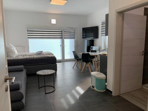 ein Wohnzimmer mit einem Bett und eine Küche mit einem Tisch in der Unterkunft H&E Apartments Barntrup in Barntrup