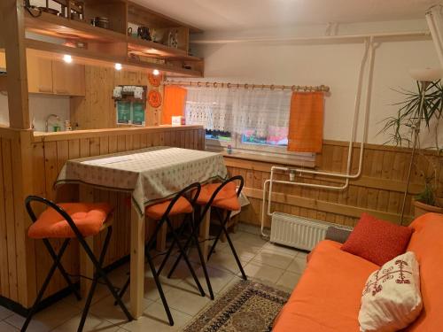 uma cozinha com uma mesa e cadeiras e um sofá em Apartma Metka em Mojstrana