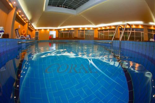 ein großer Pool mit blauem Wasser in einem Gebäude in der Unterkunft Coral Baghdad Hotel in Bagdad