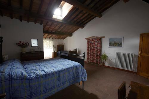 a bedroom with a bed with a blue comforter at Casina Della Burraia in Subbiano