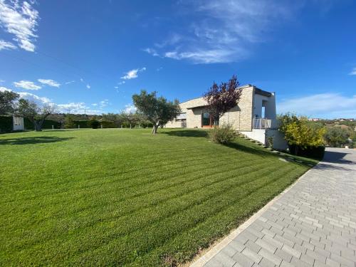 a large grassy yard with a house in the background at Gioia In Collina in Torrevecchia Teatina